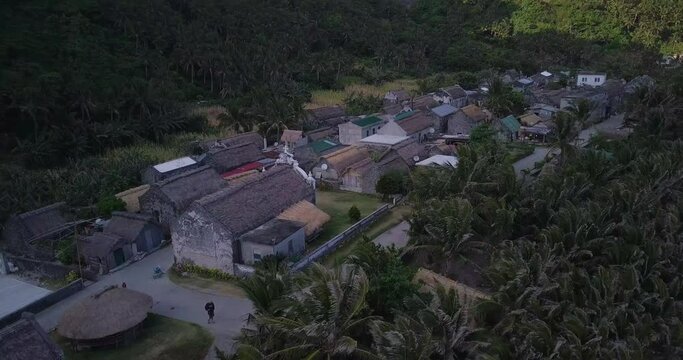 Drone footage over a small residential area surrounded with forests in Batanes, Philippines