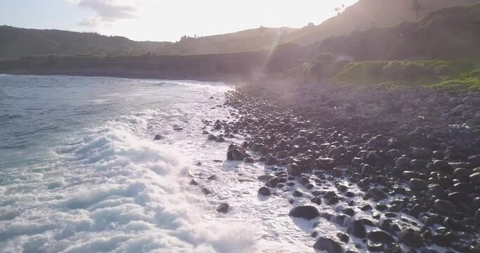 Coastline of Batanes Island,Philippines.Waves wash the rocky shore under the evening rays of the sun