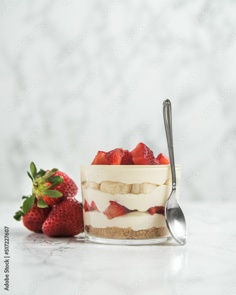 Poster Closeup of a strawberry and banana dessert in a jar on a white table