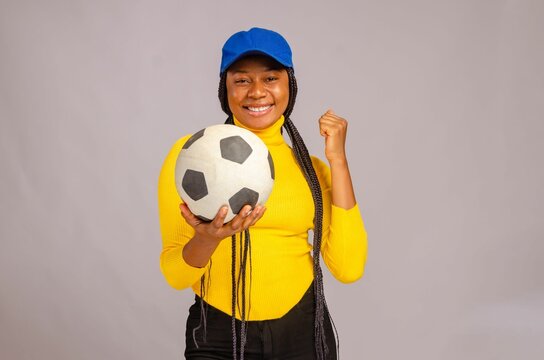Happy African woman holding a soccer ball on isolated white background
