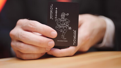 Dealer show the joker card from deck of black cards