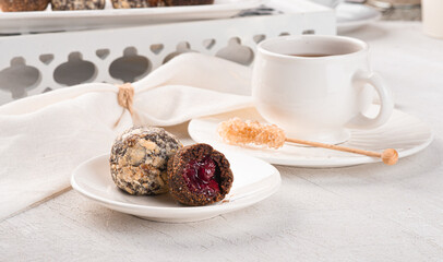 Handmade chocolate truffles on a light background. Kitchen table with white tablecloth and crockery