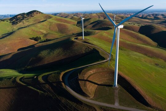 Aerial drone shot of the windmills in hills for renewable energy