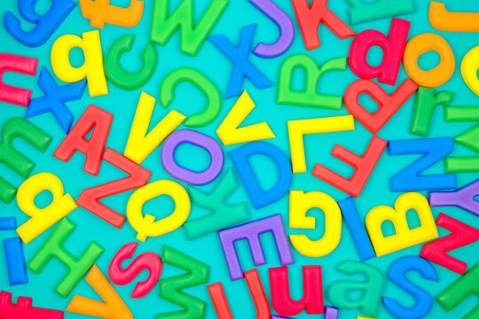 Colorful English alphabets made of foam (as learning instrument for kid), on green background
