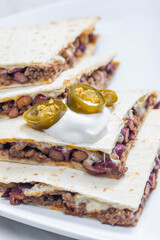 quesadilla filled with minced beef meat, beans and cheese