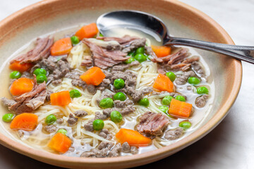 beef broth with green peas, carrot and small meatballs