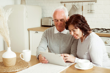 Senior couple using digital tablet at home