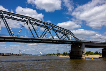 Obraz premium Detail of Snelbinder bridge seen from the water. River Maas waterfront shore of historic Hanseatic city Nijmegen