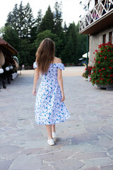 the girl walks in the summer in a light dress