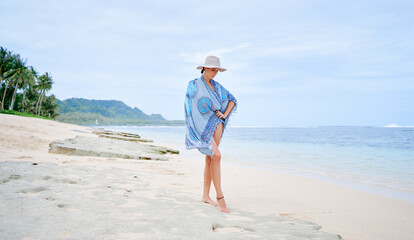 Summer vacation. Youg woman at hat posing on tropical beach.