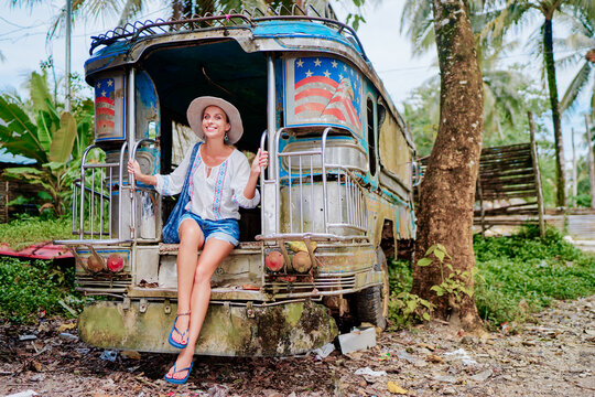 Traveling Asia. Young pretty woman in traditional philippines bus jeepney.