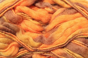 Close-up of colourful orange and brown merino wool striped background. Abstract handmade craft...