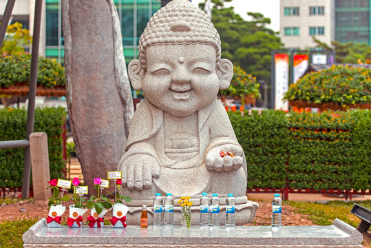 SEOUL - OCT 01: Smiling stone buddha statue with gifts  at the Jogyesa temple in Seoul, October 01. 2016 in South Korea