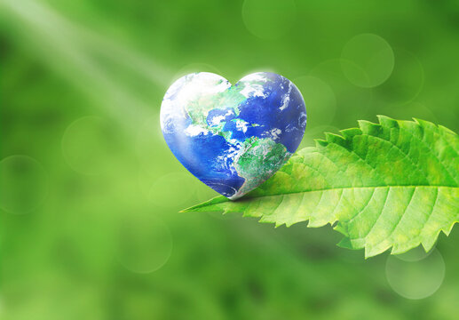 Love Environment and Natural day concept, World in heart shape sitting on green leave in natural green blur background, , Elements of this image furnished by NASA
