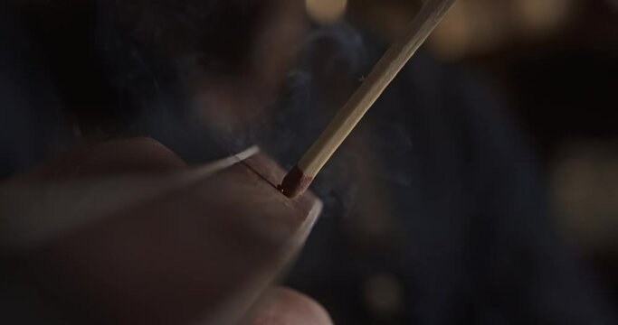 Match ignition on a matchbox held by the hand of a caucasian man, Macro view, 4K Super Slow motion, 240fps, macro shot, Apple prores HQ