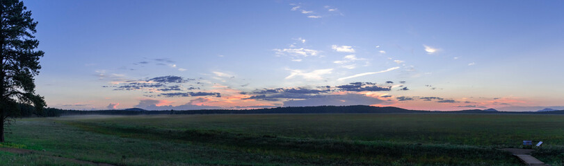 Panorama of a sunset over a mountain meadow