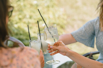 Friends having lemonade drinks on outdoors terrace. Summer lifestyle. - obrazy, fototapety, plakaty