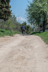 Obraz premium A man riding a bicycle on the driveway in the park.