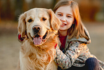 Preteen girl with golden retriever dog