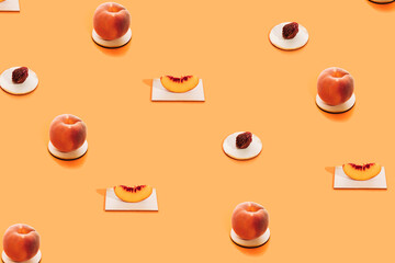 Pattern made of fresh peach fruit, slice and  peach pit on stand on bright orange background. Minimal health and organic concept. Creative fruit layout.