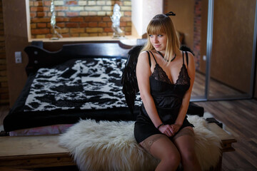 beautiful girl in black lingerie with black angel wings in a loft interior - obrazy, fototapety, plakaty