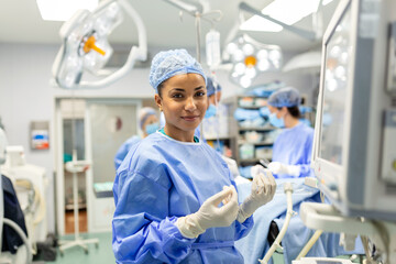 Portrait of a young female doctor in scrubs and a protective face mask preparing an anesthesia...