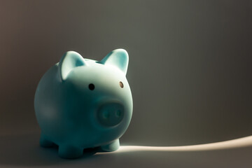 Black piggy bank on table against dark background with space for text. Poverty concept