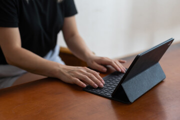 Young woman holding the tablet and sitting at home.