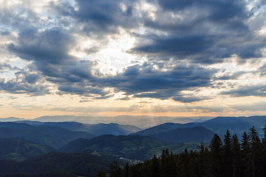 Cloudy weather over hills covered with spruce forests in Rhodope Mountains and fog between mountain ranges © YouraPechkin