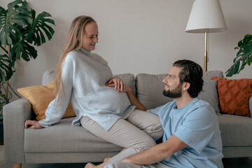 Happy young future parents waiting for childbirth, showing love and affection to unborn child....