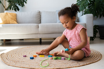 African american little girl playing with eco friendly toy. Toddler black kid play with plastic...