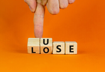 Use or lose symbol. Concept words Use or lose on wooden cubes. Businessman hand. Beautiful orange table orange background. Business Use or lose concept. Copy space.