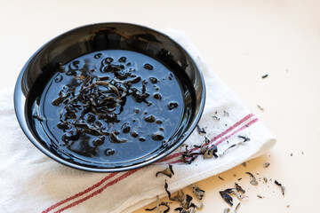 Dried mun mushrooms, Chinese traditional medicine and cuisine. Fungi ingredients in plate on beige background