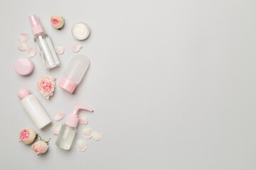 Set of small cosmetic bottles on color background, top view