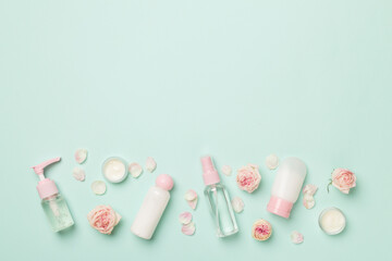 Set of small cosmetic bottles on color background, top view