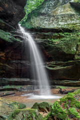 After spring rains, a beautiful ephemeral waterfall on Queer Creek plunges over a sandstone cliff recess in scenic Hocking Hills State Park in southeast Ohio.