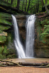 Fototapeta premium Rockstull Falls, a beautiful and secluded waterfall in the forest of the Hocking Hills region of southeast Ohio, splashes down a sandstone cliff after spring rains.