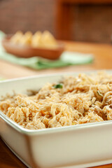 Shredded chicken platter with chicken croquettes on a wooden table.