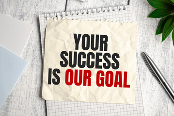 Your Success is our goal words on sheet of paper on wooden background