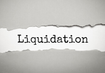 liquidation word on white torn paper. bankruptcy concept
