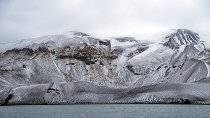 Snow dusted mountains above the crater bay in Deception Island, Antarctica