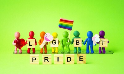 Multicolored plasticine people stand in a row with wooden cubes in their hands with the inscription pride, ice cream, lgbt flag.  The concept of unity, gender equality.  Background image, front view.