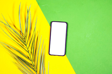 Mobile smartphone with palm tree decorated on green and yellow background