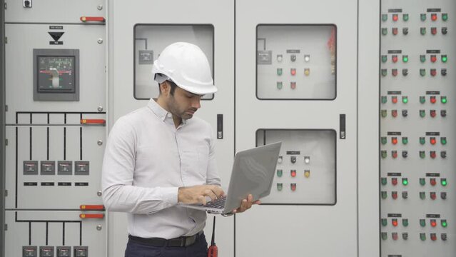 An engineer man or worker, people working in electrical room. Power energy motor machinery cabinets with panel in control or server room, operator station network in industry factory. Switchgear