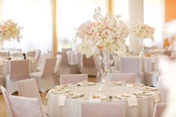 festive wedding decoration. Beautiful fresh white and pink flowers in glass vase on dining table on wedding day. High quality photo