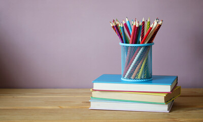 Back to school background. Textbooks and colored pencils.