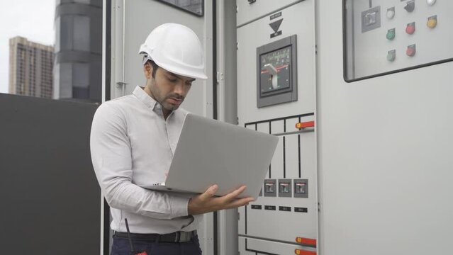 An engineer man or worker, people working in electrical room. Power energy motor machinery cabinets with panel in control or server room, operator station network in industry factory. Switchgear