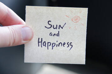 Sun and happiness. Creative concept. Hand holding a tag with the inscription.
