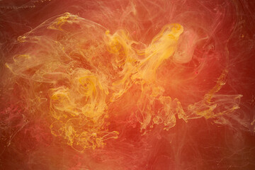 Liquid fluid art abstract background. Red, yellow dancing acrylic paints underwater, space smoke ocean, color explosion