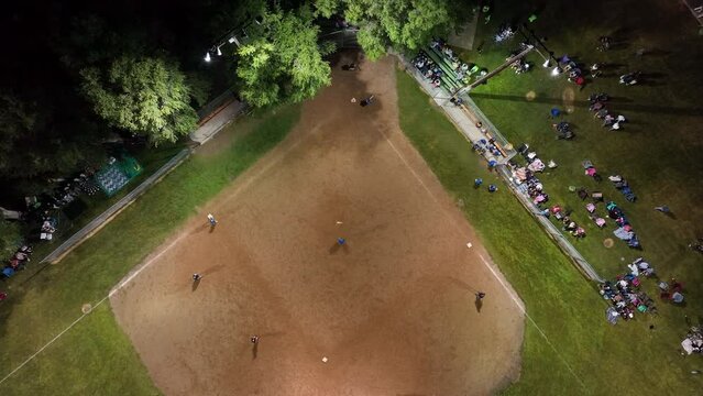Aerial night softball game lights rural climb. Small rural community play softball. Village city celebration. Team spirit and teamwork. Sports, recreation and healthy exercise.